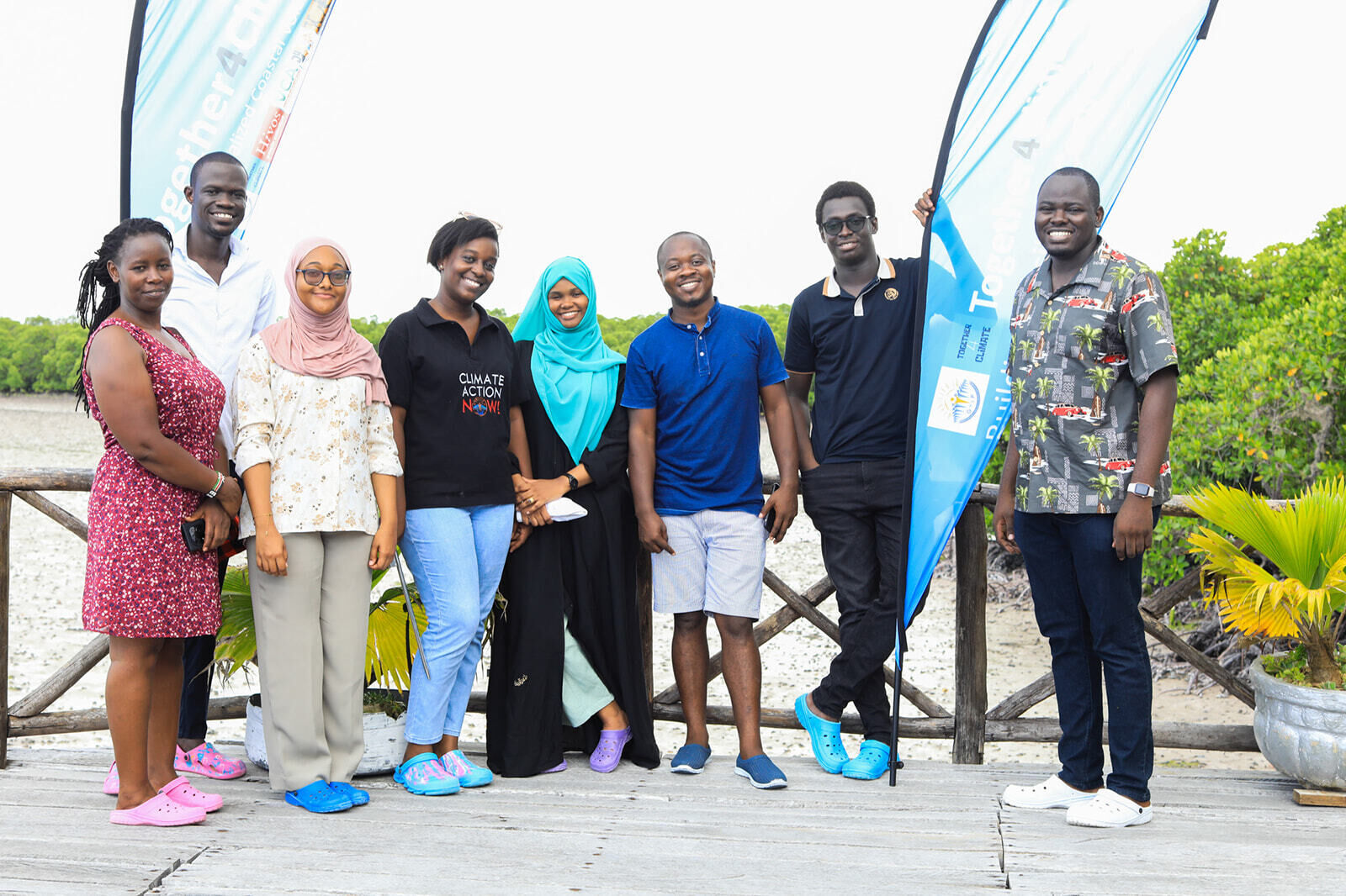 Several individuals gather on a dock, with a sign visible nearby.